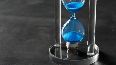 Time is passing Blue hourglass close up